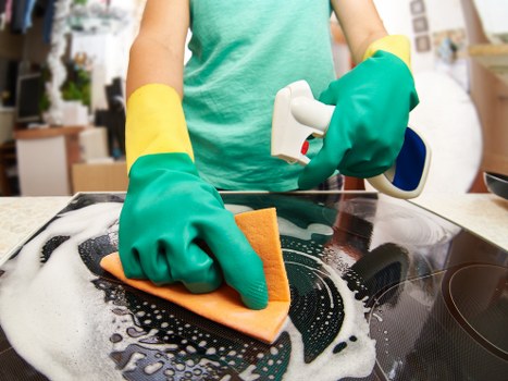 Safety-focused oven cleaning technician working carefully in a home kitchen